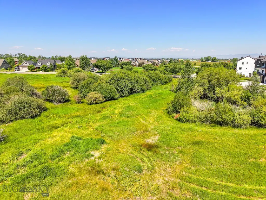 Sunny aerial view of a grassy Meadow Bridge lot with homes nearby