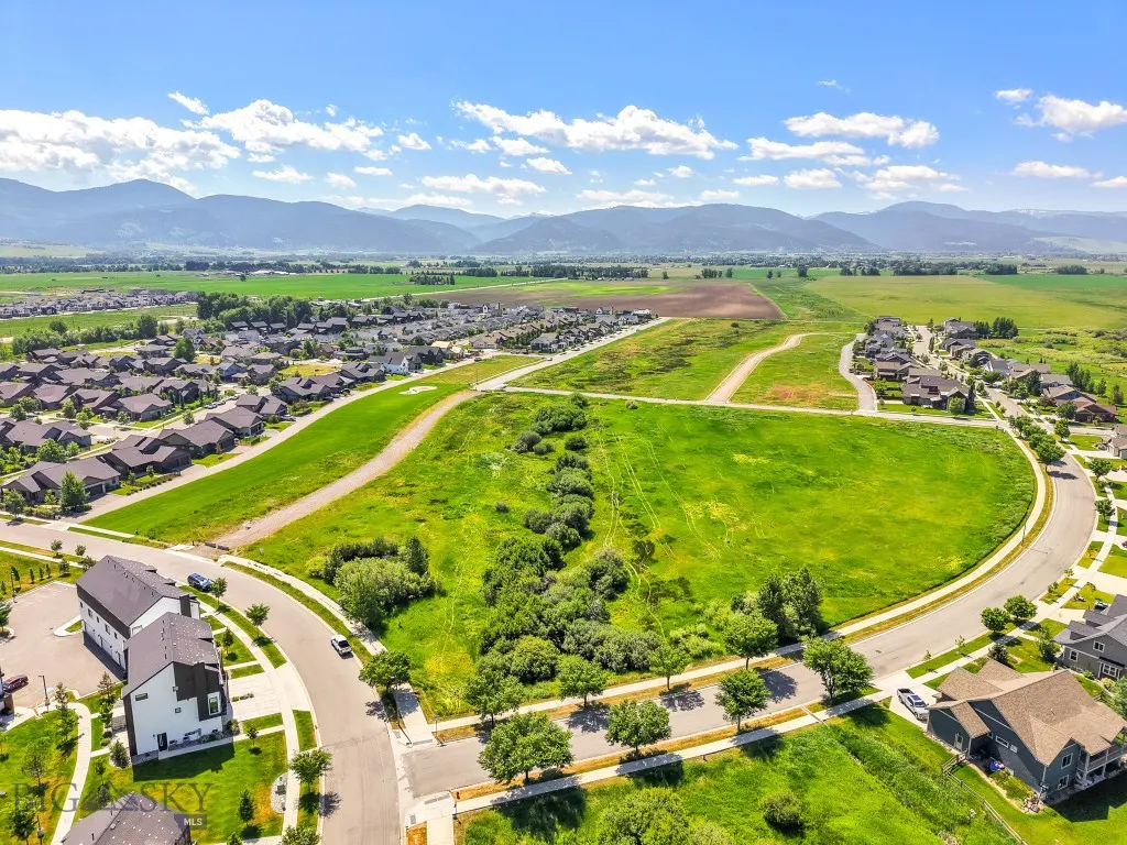 Aerial view of Meadow Bridge green field with homes and mountains