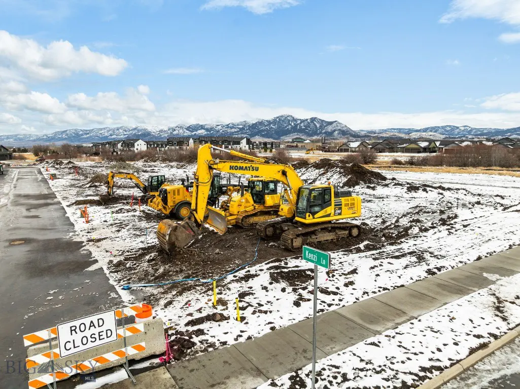 Meadow Bridge construction site with excavators, snowy ground, and mountains